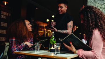 Woman in a cafe ordering to waiter