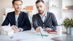 Portrait of real estate agent helping client choosing house in agency